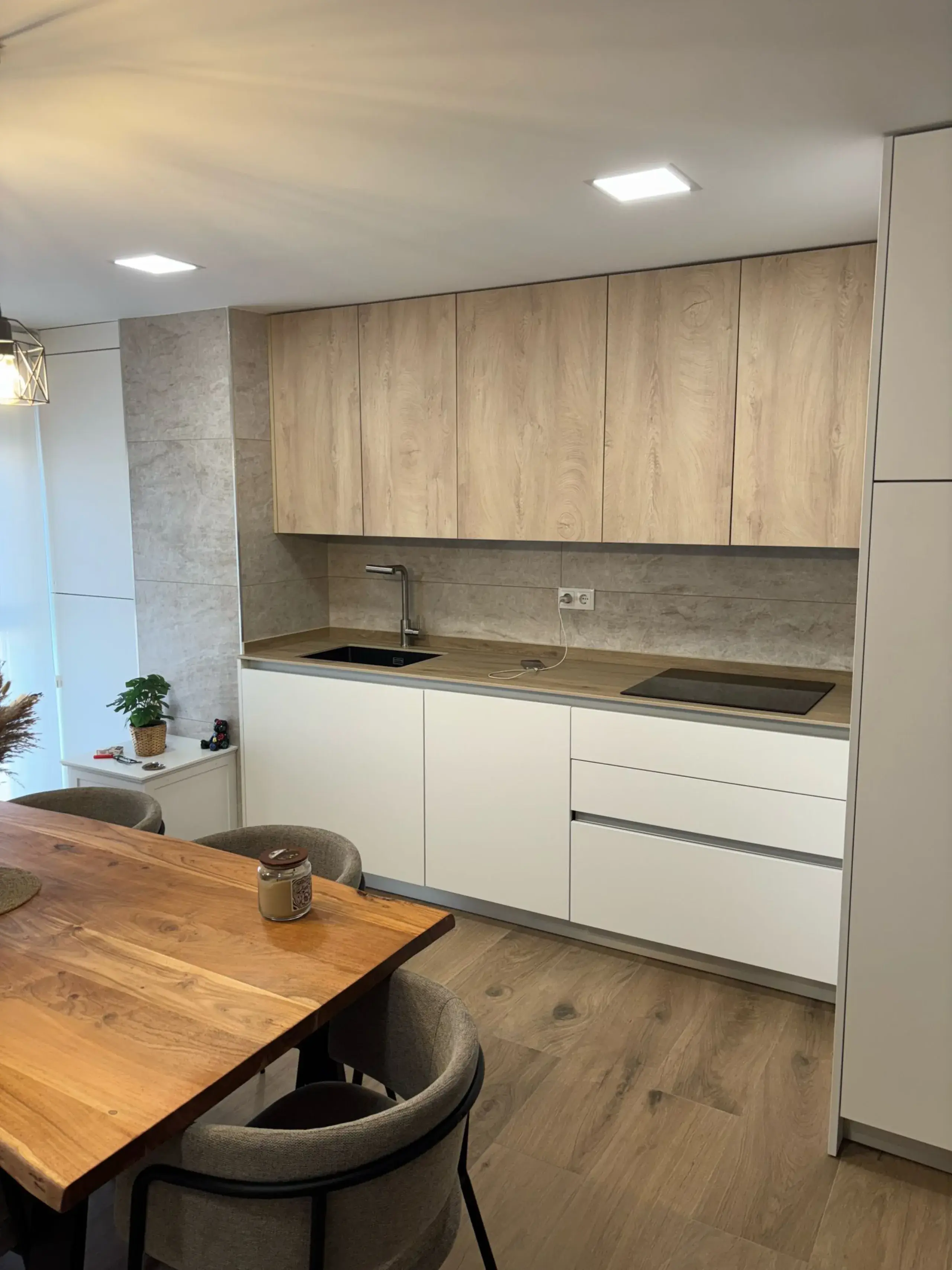 Muebles bajos blancos y muebles altos de madera junto a la mesa