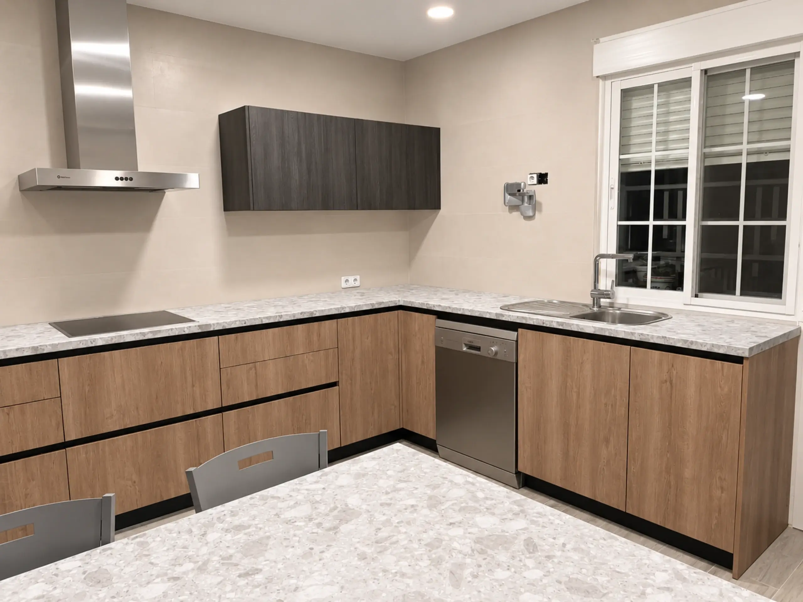 Cocina en L en madera con encimera de piedra clara, campana de acero y ventana