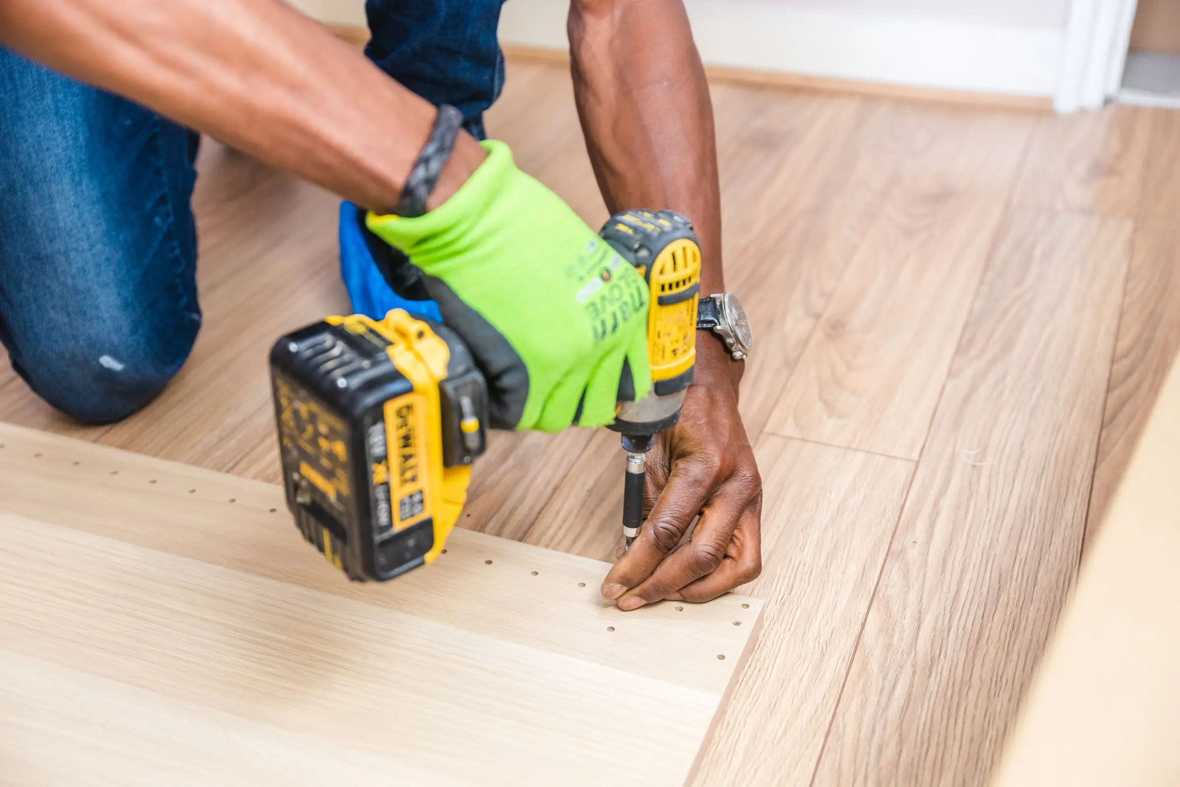 Montador fijando una pieza de madera con un atornillador